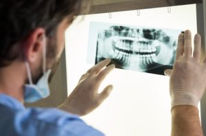 male dentist examines dental x-rays