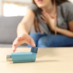 woman reaching for asthma inhaler