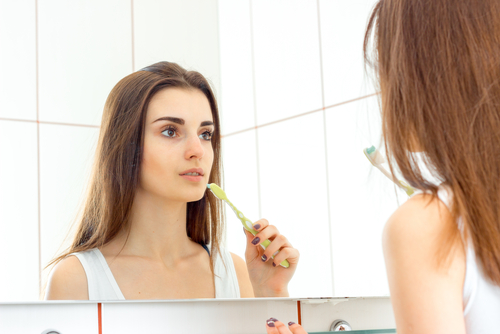 young woman brushes teeth